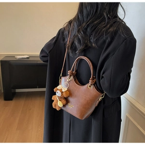 Braune Schultertasche aus PU-Leder mit Rundgriff und süßem Plüschbären-Anhänger