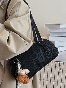 Vintage leopard print suede underarm bag with cute plush dog pendant in lifestyle shot