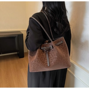Detail of vintage leopard print tote bag with metallic buckle and shoulder straps