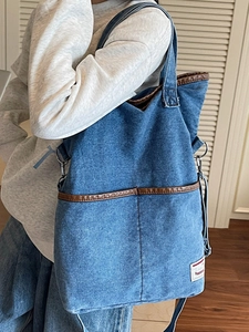 Chic blue denim canvas tote bag with brown leather trim and dual straps for daily use