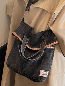 Dark grey denim canvas tote bag with brown trim and adjustable crossbody shoulder strap