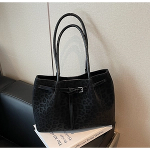 Detail of vintage tote bag with leopard print texture and silver buckle strap