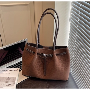 Close-up of leopard print tote bag texture and buckle detail on leather shoulder strap