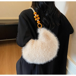 Détail d'un sac à bandoulière en fausse fourrure avec des perles orange et blanches