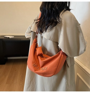 Orange canvas dumpling bag showing back-view fit and MULAIDI embroidery detail