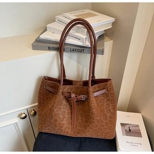 Detail of leopard print suede tote bag with slim leather handles and buckle strap decor