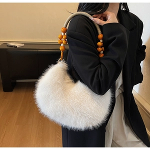 Détail du sac à bandoulière en fausse fourrure blanche avec poignée en perles orange bois