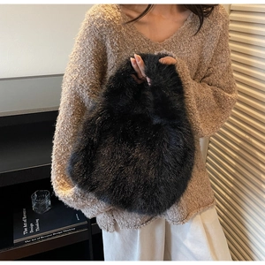 Détail d'un sac à main en fausse fourrure noire avec des fibres scintillantes et douces