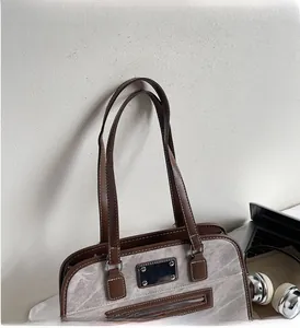 Detail shot of the minimalist tote bag showing gray fabric texture and brown leather straps