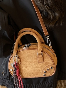 Minimalist tan suede bowling style crossbody handbag with double handles and shoulder strap