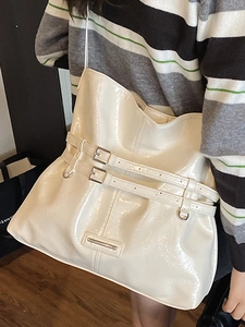 Fashionable creamy white large capacity tote bag in glossy finish worn by a model