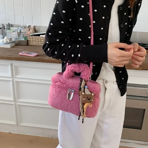 Borsa a tracolla in peluche rosa con ciondolo a forma di orso indossata da modella