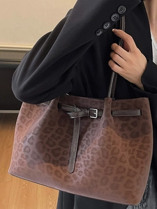 Retro leopard print tote bag with brown leather straps shown on shoulder for fashion style