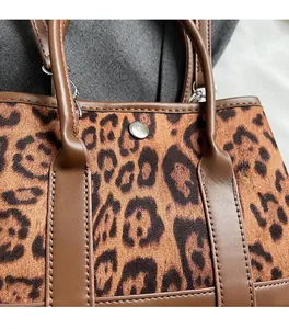 Close-up of leopard print faux fur texture and brown leather handle with silver rivets