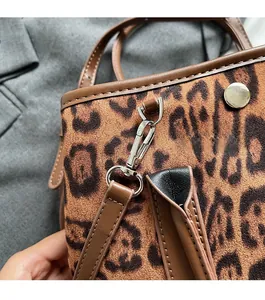 Detailed macro view of leopard print bucket bag texture and premium metal hardware hooks