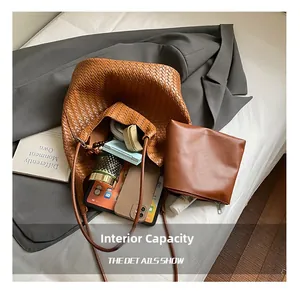 Detailed view showing large internal capacity of the brown woven leather tote bag with accessories