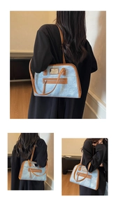 Close-up of blue denim texture and brown leather trim on a vintage shoulder bag detail