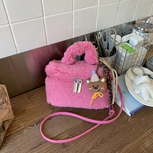 Dettaglio della borsa in peluche rosa con ciondolo a forma di orso e doppia cerniera