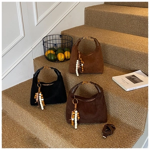 Detailed shot of retro suede hobo bags with quilted patterns and beaded tassel charms