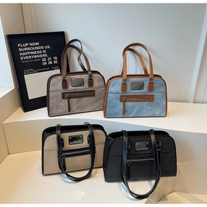 Detailed view of four retro boston bags in grey, blue, beige, and black on white steps