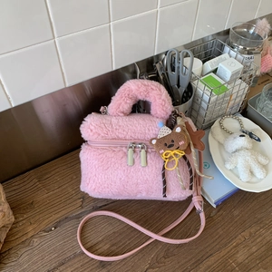 Dettaglio della borsa di peluche rosa con manico peloso e ciondolo a forma di orsetto