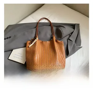 Detailed macro view of brown woven tote bag featuring decorative wooden bead tassels