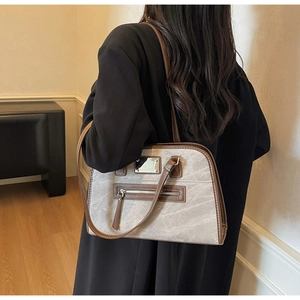Detailed view of gray retro shoulder bag with brown trim and metallic sequin accents