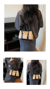 Detail showing two-tone bucket bag in brown fabric and black leather on a model