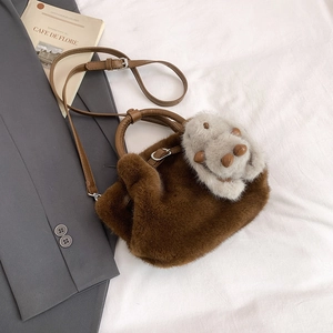 Détail du sac seau en peluche avec poignées en cuir marron et breloque lapin mignonne