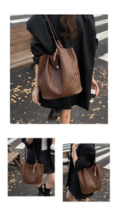 Detail of a brown woven tote bag featuring an artistic beaded charm and dual shoulder straps