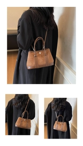 Detail of a brown suede contrast bucket bag with metallic ring buckle and adjustable strap