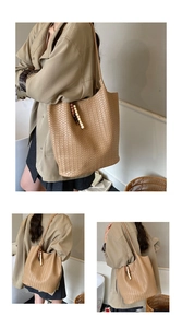 Detailed close-up of woven herringbone pattern and wooden bead tassel on the tote bag