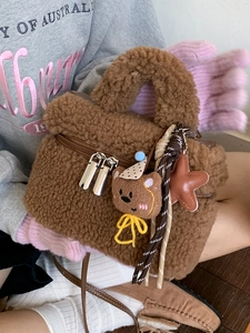 Borsa a mano in peluche marrone con ricamo a orsetto e ciondoli in un'atmosfera autunnale