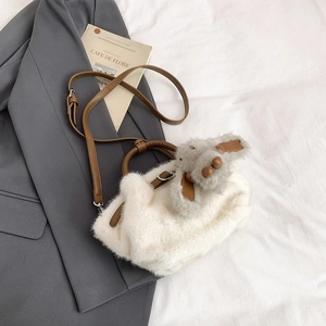 Détail du sac bandoulière en peluche blanche avec sangle en cuir et pendentif lapin
