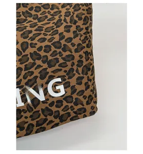 Close-up of leopard print canvas fabric with white ING letter print and twill texture