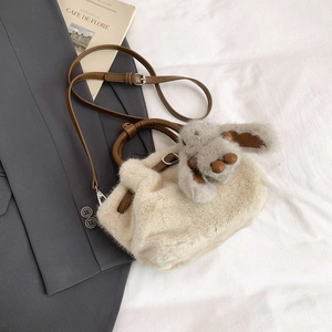 Gros plan du sac seau en fausse fourrure douce avec un joli pendentif lapin