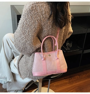 Lifestyle shot of a pink contrast bucket bag with metal buckle and detachable strap