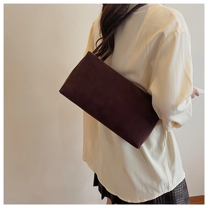 Detailweergave van de donkerbruine suède schoudertas met een minimalistische retro-look