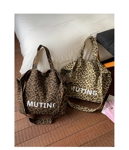 Detail view of large leopard print canvas tote bags with Muting print and shoulder straps