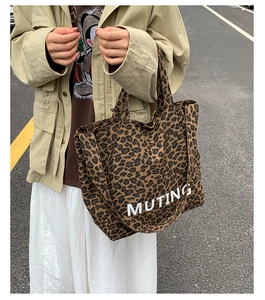 Detailed close-up of leopard print canvas tote bag with white MUTING letter branding