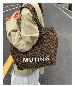 Detail view of large leopard print canvas tote bag with white MUTING lettering