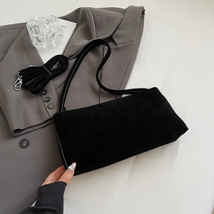 Detail van zwarte matte pillow bag met suède textuur en verstelbare schouderriem