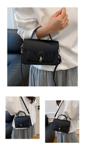 Detailed macro view of black lychee grain leather handbag with gold rotating lock