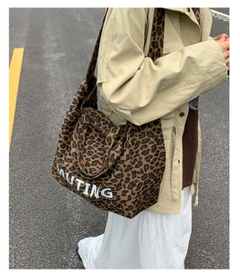 Detail of canvas leopard print tote bag with MUTING text and reinforced dual handles