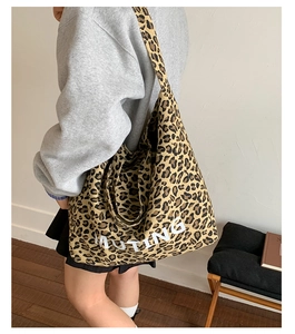 Close-up of leopard print canvas tote bag featuring MUTING text and thick shoulder strap