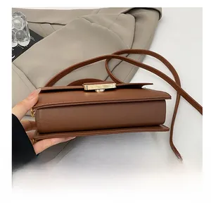 Detail of the brown pebble leather bag side and base with elegant golden metal twist lock