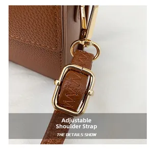 Macro detail of adjustable brown leather shoulder strap with premium gold hardware