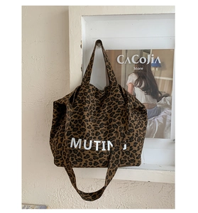 Detailed macro view of heavy-duty leopard print canvas tote bag with MUTING logo print