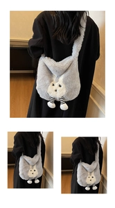 Detail view of a fluffy light grey rabbit plush crossbody bag worn on person in-door