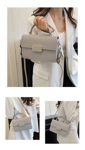 Detail of grey lychee leather handbag with gold metal clasp and versatile shoulder strap